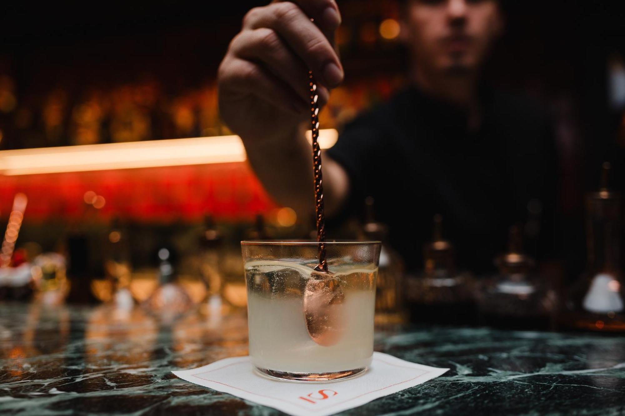 Sly Berlin Hotel Buitenkant foto A bartender adding a garnish to a cocktail